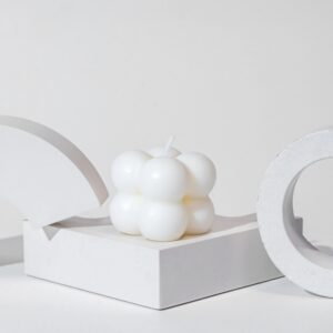 white bubble candle on concrete podium on white background, minimal copy space background for presentation cosmetic product with bright natural sunlight.
