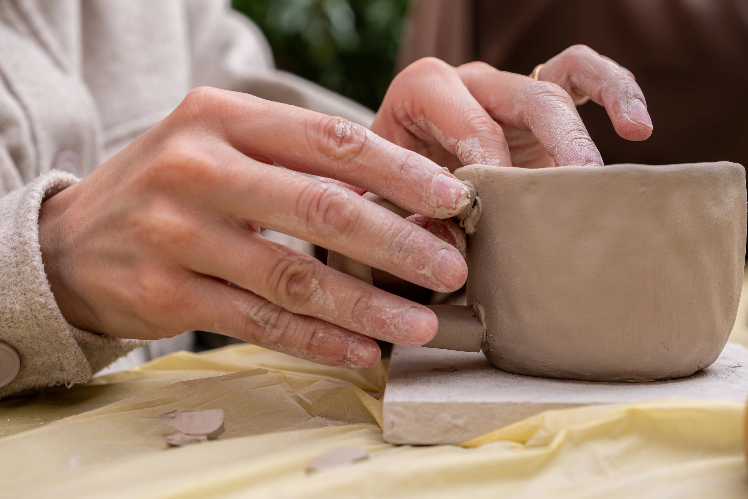 Hands shaping ceramic product in pottery workshop